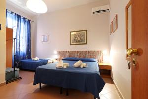a bedroom with two beds with blue sheets and towels at casa ros via ostiense 73 in Rome