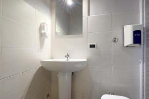 a white bathroom with a sink and a toilet at casa ros via ostiense 73 in Rome