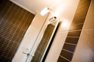 a light on a wall next to a bathroom mirror at Melon Suites in Thessaloniki