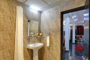 Hotel Windsor Castle Inn Brigade Rd في بانغالور: حمام مع حوض ومرآة