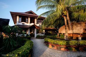 uma casa com uma palmeira em frente em Kasai Village Dive Resort em Moalboal