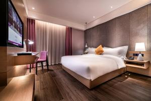 a bedroom with a large white bed and a desk at Mercure Suzhou Downtown in Suzhou
