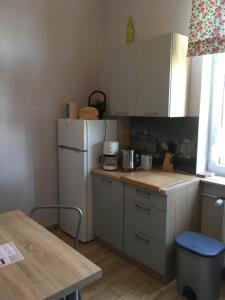 a kitchen with a white refrigerator and a table at Apartament Ołowianka- Danzig in Gdańsk