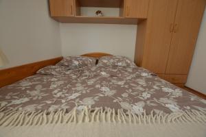 a bed with a gray and white blanket on it at Maja in Kornić