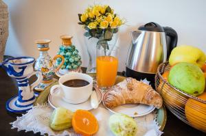 einen Frühstückstisch mit einer Tasse Kaffee und einem Obstkorb in der Unterkunft Masseria Testaferrata in Syrakus