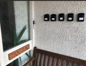 a wall with three cell phones on a wall with a bench at The Clan Boyd Room in Kilmarnock