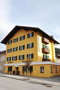 un edificio giallo con balconi sul lato di Hotel Gasthof Tirolerwirt a Bischofshofen