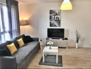 sala de estar con sofá y mesa en Beautiful 3 bedroom flat 8-9 persons, en Ivry-sur-Seine