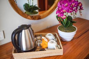 a table with a tea kettle and flowers on it at Bisma Terrace Suite Ubud in Ubud