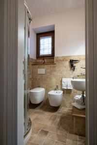 a bathroom with two sinks and a tub and a toilet at B&B Terra di Marca in Montefortino