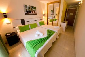 a hotel room with two beds with green sheets at Hostal San Marcos in San Martín de la Vega