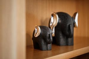two black elephant statues sitting on a wooden shelf at Melon Suites in Thessaloniki