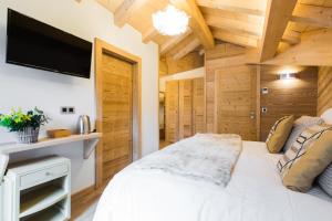 1 dormitorio con 1 cama blanca y TV de pantalla plana en Chalet sur les monts Morzine en Montriond