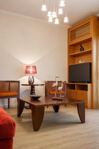 a living room with a coffee table and a tv at Melon Suites in Thessaloniki
