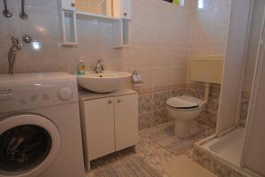 a bathroom with a washing machine and a sink at Maja in Kornić
