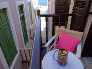 una mesa y una almohada rosa en el balcón en Muse Neate, en Halki