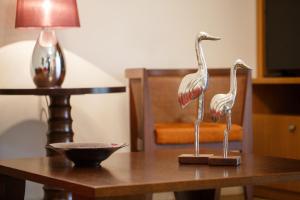 two statues of flamingos on a wooden table at Melon Suites in Thessaloniki