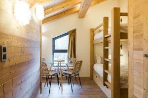 Cette chambre comprend une table, des chaises et des lits superposés. dans l'établissement Chalet sur les monts Morzine, à Montriond