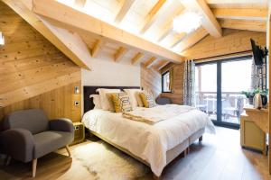 ein Schlafzimmer mit einem großen Bett und einem Stuhl in der Unterkunft Chalet sur les monts Morzine in Montriond