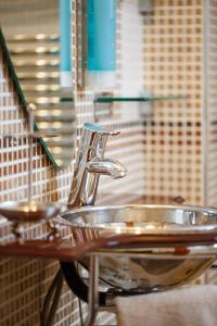 a bathroom sink with a faucet and a mirror at Melon Suites in Thessaloniki