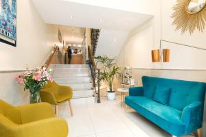ein Wohnzimmer mit einem blauen Sofa und gelben Stühlen in der Unterkunft Hotel Florence Nice in Nizza