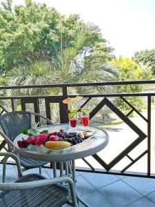 a table with a plate of fruit on a balcony at Hilton Gardens Guesthouse in Richards Bay