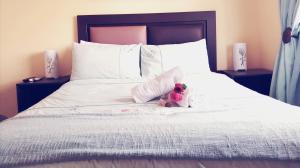 a stuffed teddy bear sitting on top of a bed at Hilton Gardens Guesthouse in Richards Bay