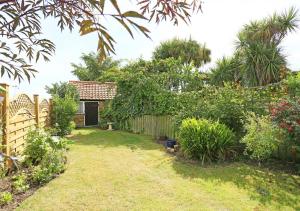 a garden with a fence and a yard at Hollyhocks in Bawdsey +6 photos