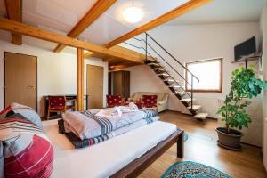 a bedroom with a large bed and a staircase at Rodinný penzión Rogalo in Mengusovce +33 photos