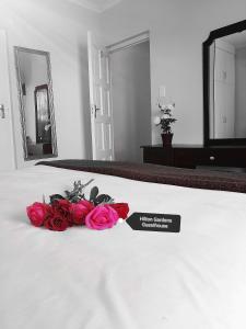 a bunch of roses sitting on top of a bed at Hilton Gardens Guesthouse in Richards Bay