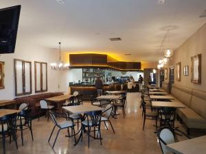 エル・トボソにあるHostal Restaurante Dulcinea de El Tobosoのテーブルと椅子のあるレストラン、バー