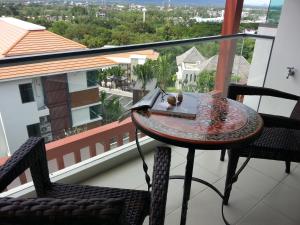 a table and chairs on a balcony with a view at Top Floor, One-Bedroom Apartment in Phuket Town