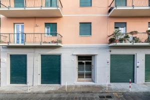 een gevel van een appartementencomplex met groene garagedeuren bij Le Mura room&breakfast in Genua