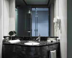 
a bathroom with two sinks and a mirror at Golden Tulip Zira Belgrade in Belgrade
