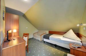 Habitación pequeña de 2 m2 con cama, escritorio y cama. en Hotel Belweder - przy hotelu Golebiewski en Karpacz