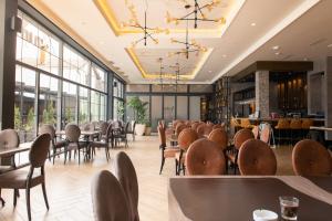 a dining room with tables and chairs and windows at Hotel Nota in Belgrade