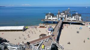 a group of people on a beach near a pier at Ferienwohnung Mönchgut 1 mit Wintergarten und Terrasse in Ostseebad Sellin