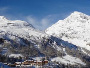 uma montanha coberta de neve com um alojamento de turismo selvagem em primeiro plano em Tignes 1800 em Tignes