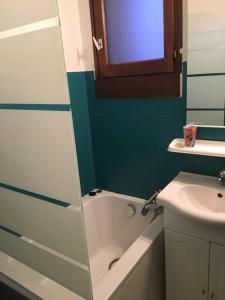ein Badezimmer mit einer Badewanne, einem Waschbecken und einem Spiegel in der Unterkunft Tignes 1800 in Tignes