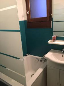 a bathroom with a bath tub and a sink and a mirror at Tignes 1800 in Tignes
