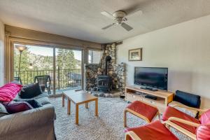 sala de estar con sofá, TV y chimenea en Scott Peak Views en Alpine Meadows