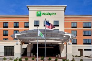 a hotel with two flags in front of a building at Holiday Inn Saint Louis-Fairview Heights, an IHG Hotel in Fairview Heights