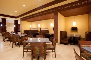 uma sala de jantar com mesas e cadeiras e um restaurante em Holiday Inn Saint Louis-Fairview Heights, an IHG Hotel em Fairview Heights