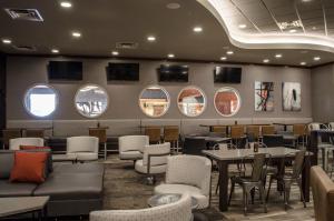 un restaurant avec des tables, des chaises et des miroirs rondes dans l'établissement Holiday Inn Fargo, an IHG Hotel, à Fargo