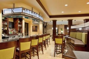 a bar in a restaurant with yellow chairs at Holiday Inn Saint Louis-Fairview Heights, an IHG Hotel in Fairview Heights
