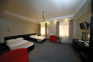 a hotel room with two beds and a desk at Belogorye Hotel in Belgorod