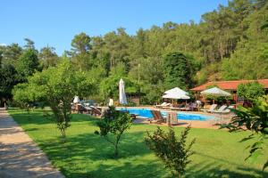 a swimming pool with chairs and umbrellas in a park at Dalya Life in Göcek