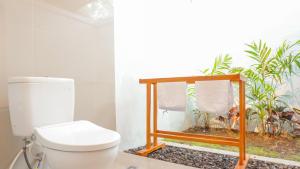 Sunburn Villa في نوسا دوا: حمام به مرحاض ونافذة بها نباتات +33 صورة