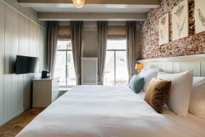 a hotel room with a bed and a television at Logement Petit Beijers in Utrecht