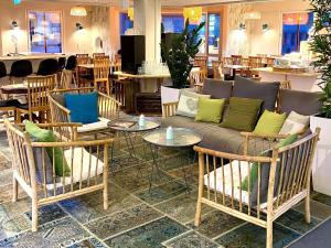 a living room with a couch and tables and chairs at Uppsala CityStay Hotel in Uppsala